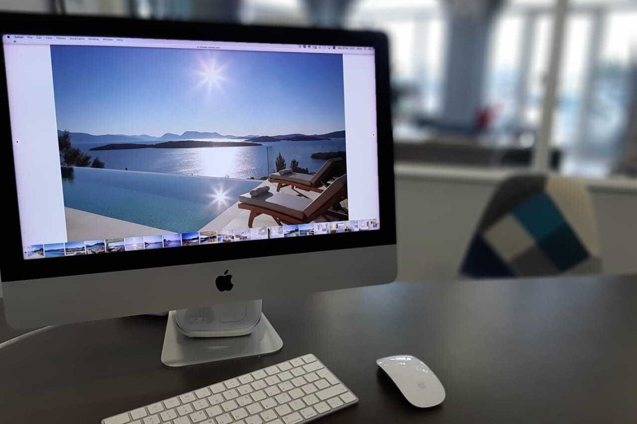 A villa with an infinity pool shown on a desktop computer screen